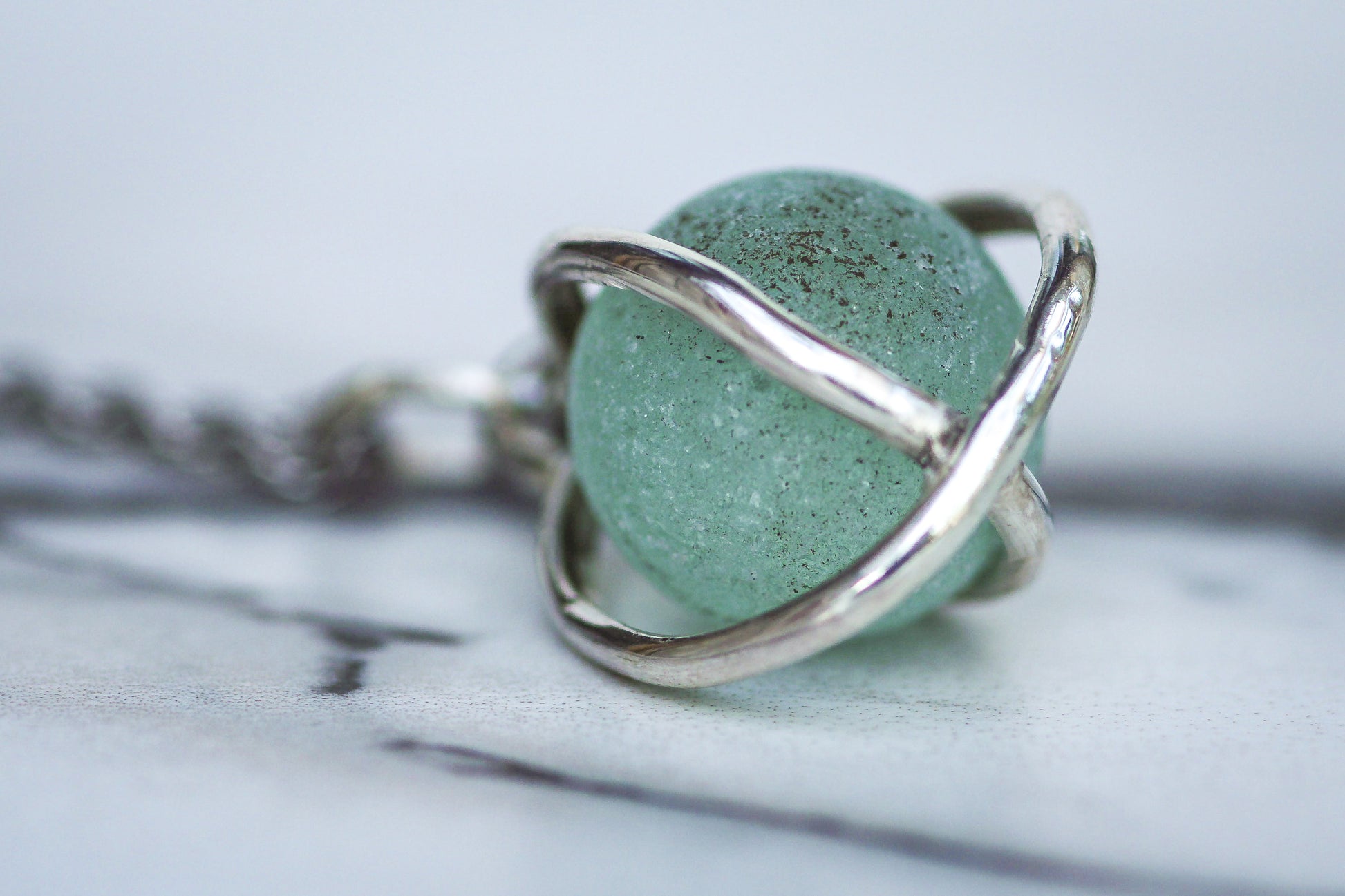 Sterling silver cage pendant holding aqua turquoise sea glass marble, fiddle necklace design