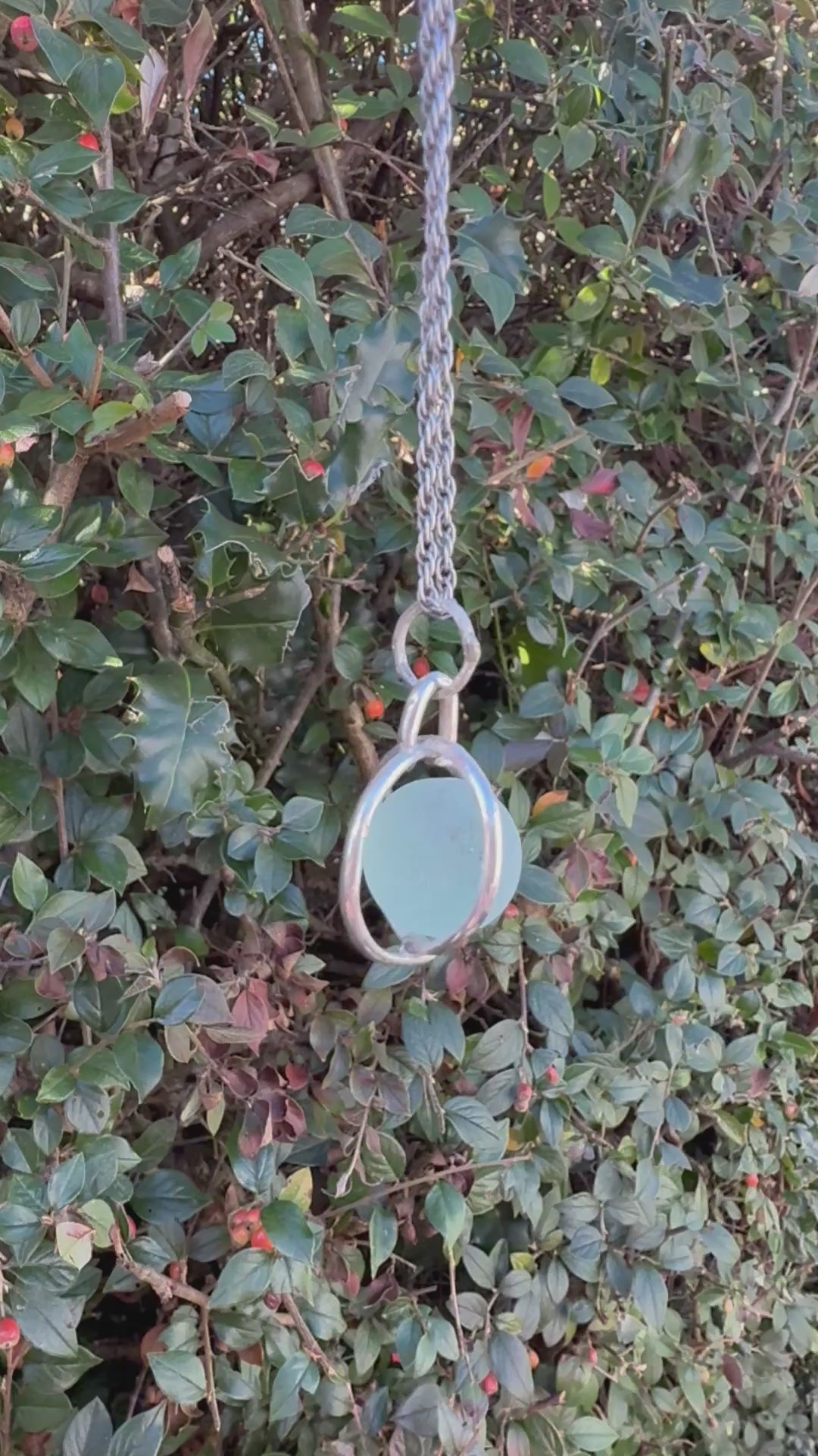 Video of turquoise Codd sea glass marble spinning freely inside sterling silver cage necklace