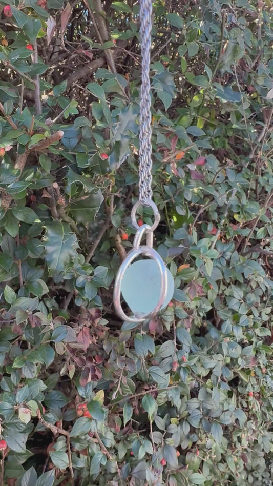Video of turquoise Codd sea glass marble spinning freely inside sterling silver cage necklace